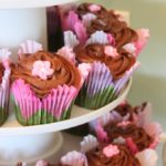 Floral cupcake liners and a royal icing flower add a Springtime touch to these chocolate frosted cupcakes.