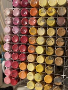 image of several colorful bottles of acrylic paint on an organized turnstyle